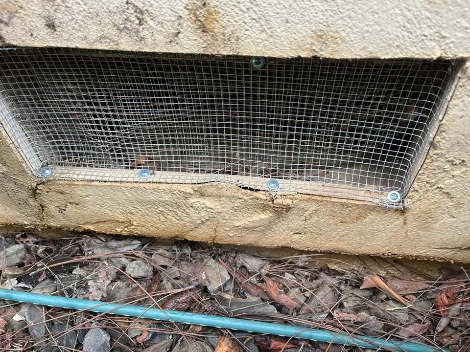 Foundation vent covered with new steel mesh, screwed in place