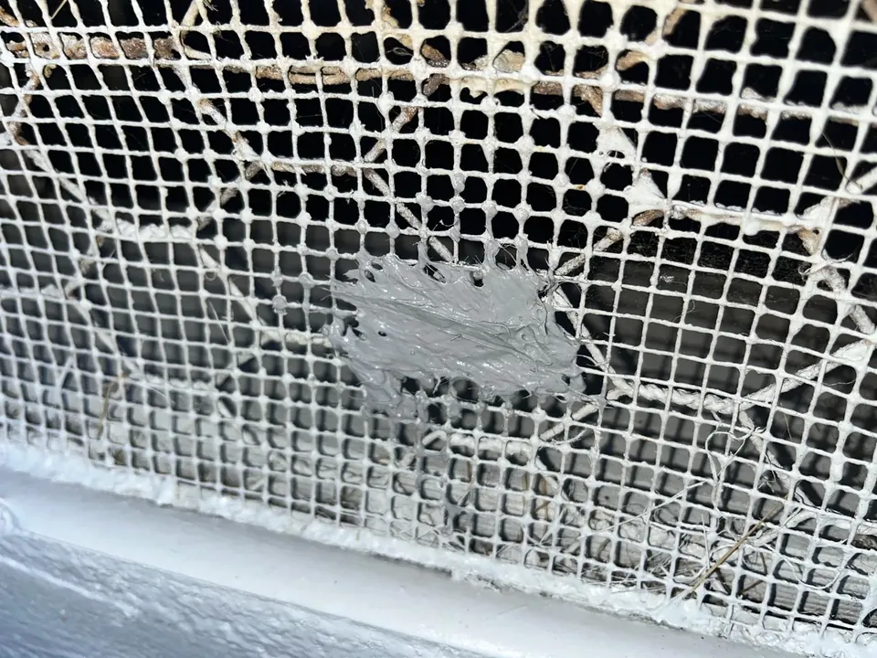 Vent screened with steel mesh, a hole patched with putty