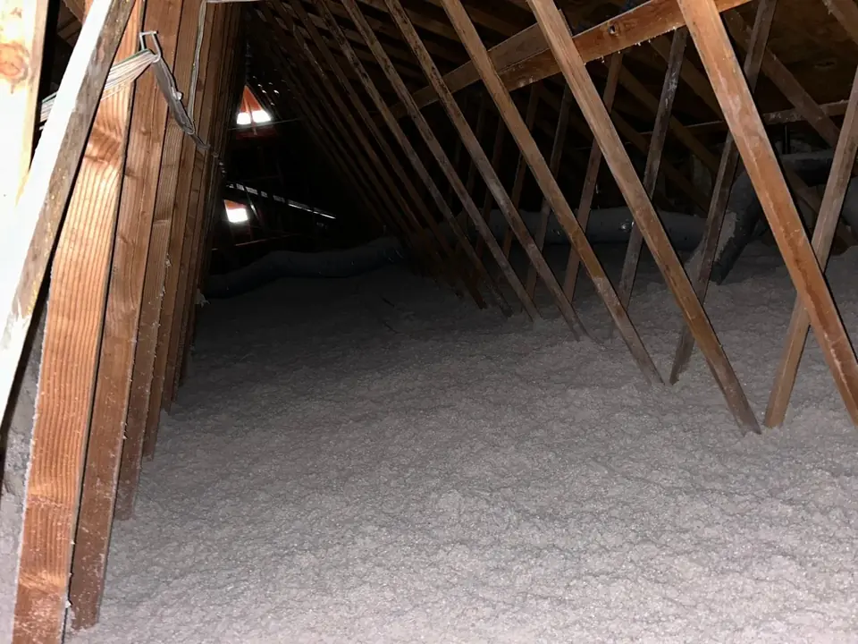 Attic with fresh blown-in cellulose insulation between the rafters