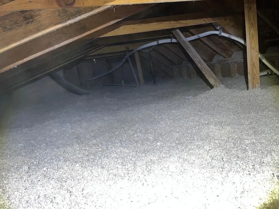 Attic floor with a fresh, even layer of insulation after the cleanup