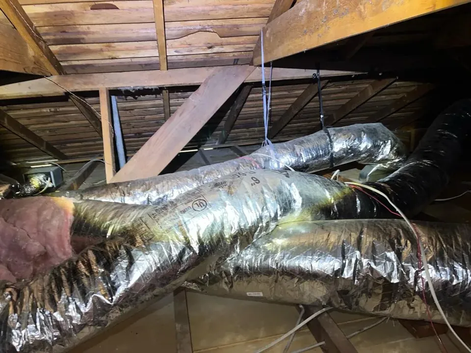 New silver flexible insulated ducts hung in an attic